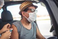 man receiving COVID vaccination while sitting in his car